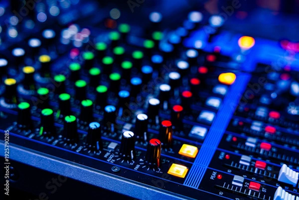 Obraz Professional Audio Mixing Console with Colorful Control Knobs in Blue Neon Lighting