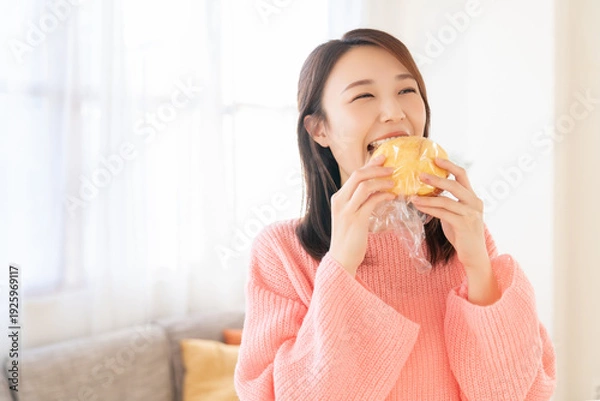 Obraz パンを食べる若い女性