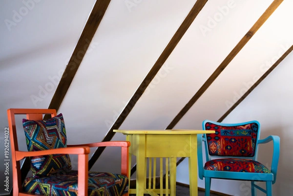 Obraz Two chairs and a small colorful table.