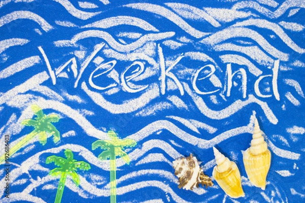 Fototapeta Weekend inscription on a blue colored sand with waves, sea shells, top view, flat lay