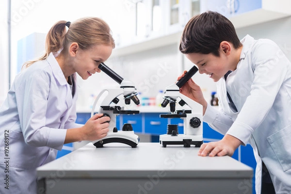 Obraz Nice smart children looking into microscopes