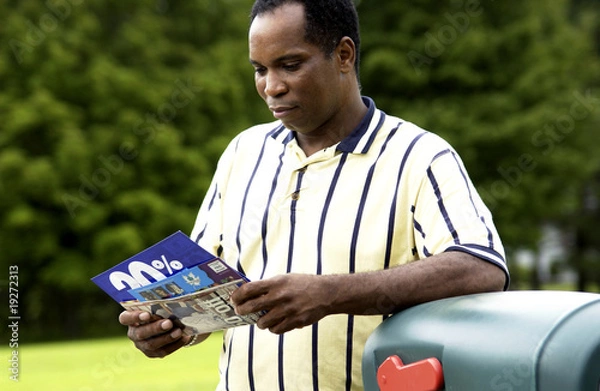 Obraz African American man getting mail from mailbox