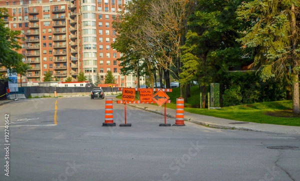 Fototapeta The cones,  road closed and local traffic only orange signs on the sidewalk in Montreal, Canada