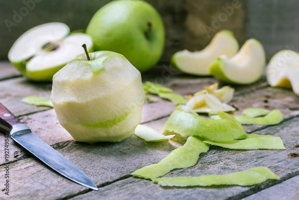 Fototapeta Green peeled apple on natural rustic wooden background.