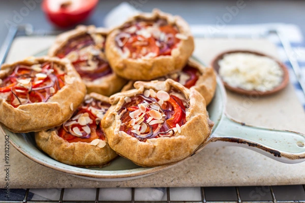 Fototapeta Mini pizza, vegetable galette with cream cheese, red onion, tomatoes, sweet pepper and almonds
