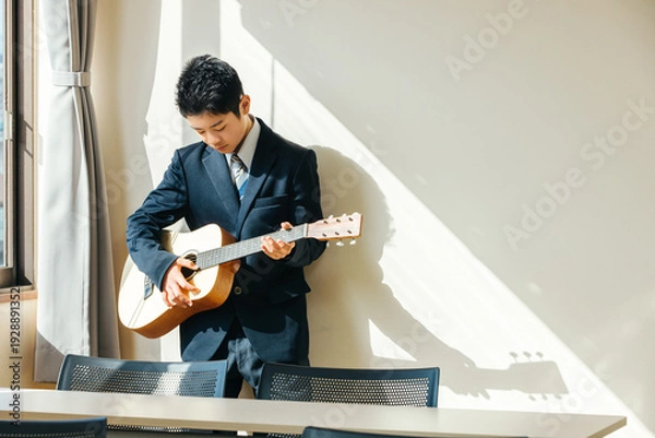 Obraz 教室でギターを弾く男子学生