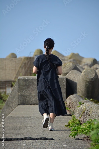 Obraz 防波堤を歩く女性