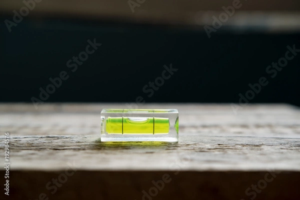 Obraz small building level lies on a wooden surface