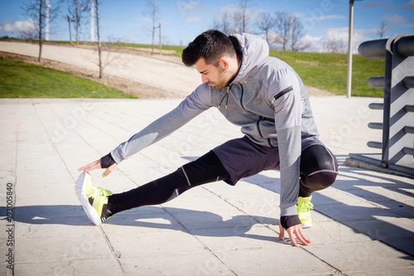 Obraz Young athletic man is preparing before running.