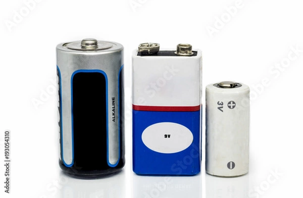 Fototapeta Alkaline batteries, 9v and 3v batteries, isolated on a white background with reflective surface