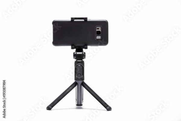 Fototapeta smart phone and tripod isolated on white background