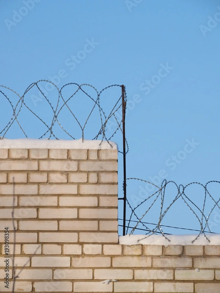 Obraz barbed wire on a brick fence