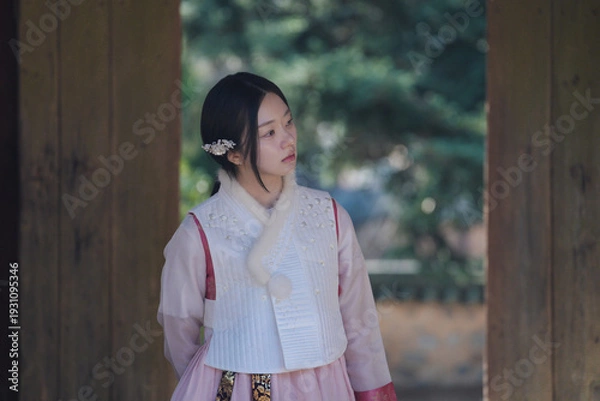 Obraz 고즈넉한 한옥 문틀 사이, 한복 여인의 사색