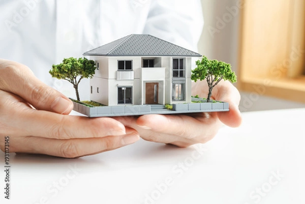 Obraz 家の模型を持つ女性の手　不動産やマイホームのイメージ素材