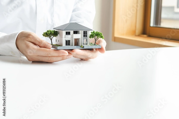 Obraz 家の模型を持つ女性の手　不動産やマイホームのイメージ素材
