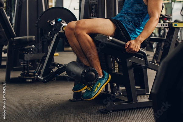 Fototapeta Closeup nice muscle runner legs with leg machine, Sport concept.