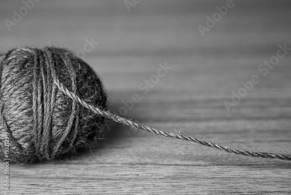 Fototapeta Tangle of knitting threads on the table and space for text, black and white photo