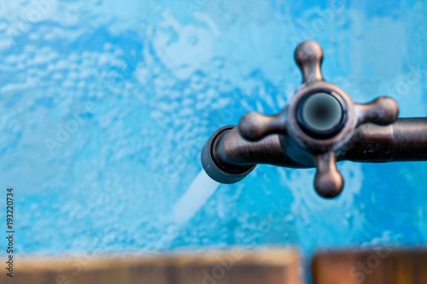 Obraz Faucet and water drop on the swimming pool and wooden deck.
