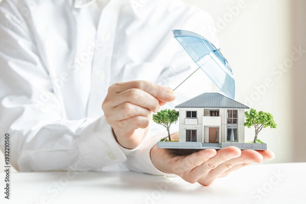 Obraz 傘で安全に守られる家の模型　住宅の火災保険や地震保険　家のセキュリティ