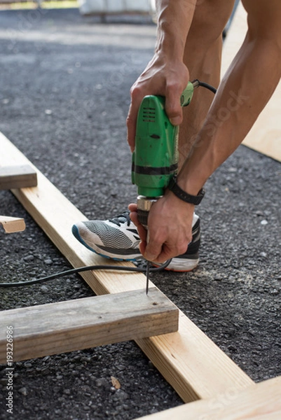 Obraz man worker working with an electric drill