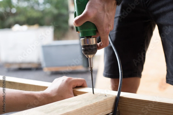 Obraz man worker working with an electric drill