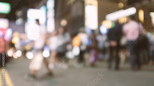 Fototapeta abstract blur and defocused people crossing the street in Hong Kong city at night for background, old film look effect