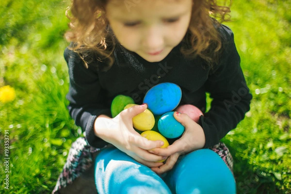 Obraz The girl is holding a collection of colorful Easter eggs.