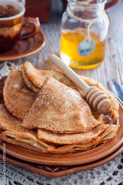 Fototapeta Homemade Russian openwork pancakes for carnival in honey, selective focus