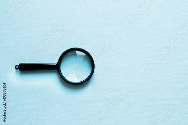 Fototapeta Black little Magnifier on a blue background