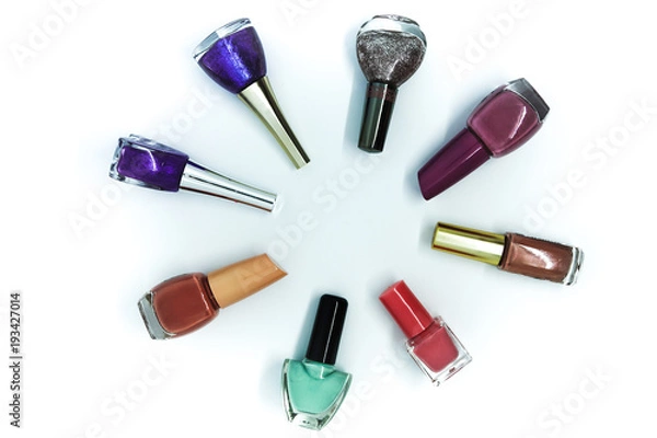 Fototapeta Coloured nail polish bottles stacked circle on a white background