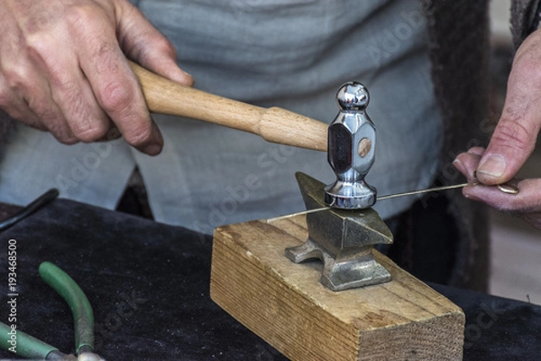 Obraz Making crafts with a small anvil and a hammer