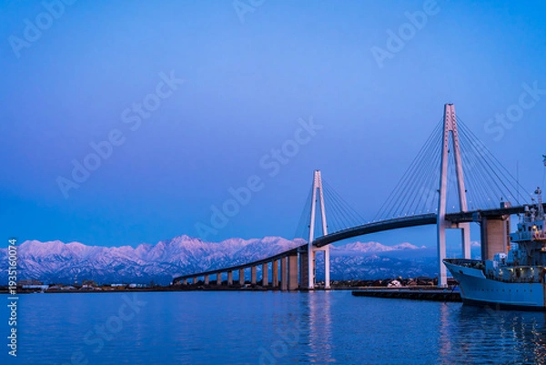 Obraz 夕方の海王丸パークから新湊大橋と海王丸を前景にピンク色染まる立山連峰アーベンロート