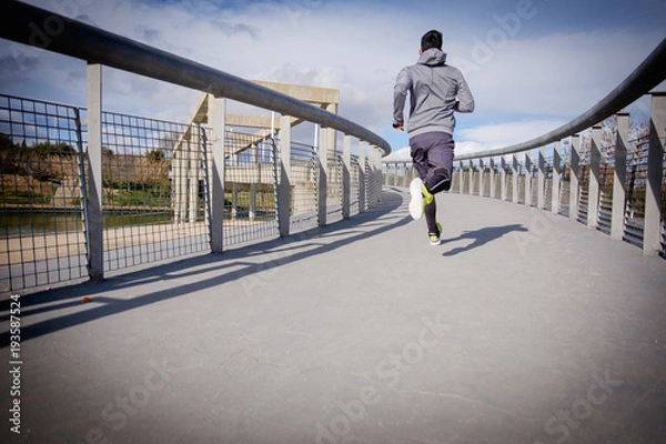 Obraz Young athlete man running in a city park