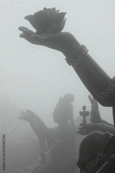 Obraz Buddha statue holding a lotus flower in the fog