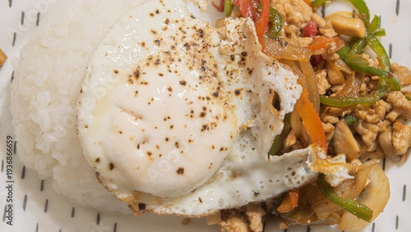 Obraz タイの人気料理ガパオライス。鶏肉のバジル炒めと目玉焼きを添えたワンプレートランチの俯瞰写真
