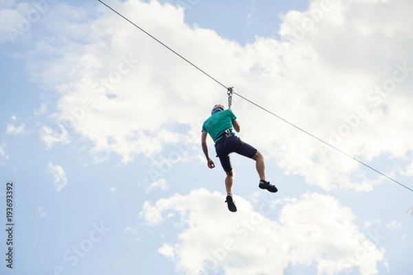 Fototapeta a man descends on a rope, a sport in an extreme park