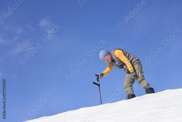 Obraz 雪国で田舎暮らしの老人が杖を使ってリハビリをしている