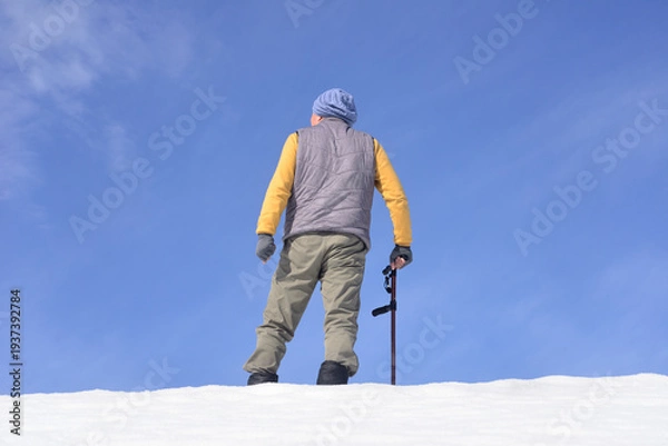 Obraz 雪国で田舎暮らしの老人が杖を使ってリハビリをしている