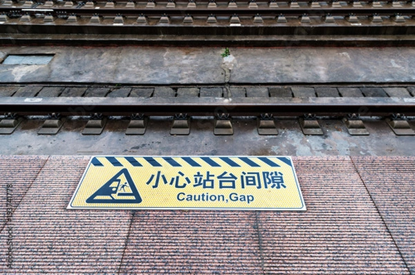 Fototapeta Mind the gap sign painted on train station's platform edge