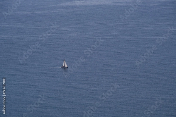 Fototapeta Lonely boat sailing at the open blue sea view from above