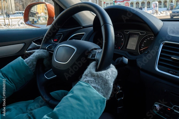 Fototapeta Female hands in the mittens on the steering wheel