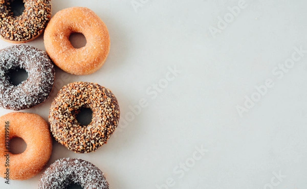Obraz Various donuts on white background. Top view.