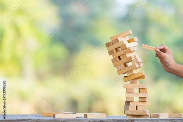 Obraz The jenga game ,tower stack from wooden blocks toy and  hand take on block