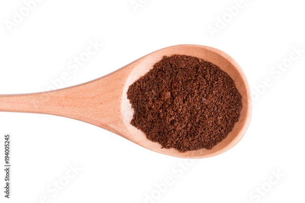 Obraz Ground coffee in a wooden spoon on a white background