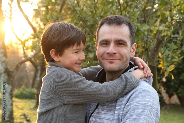 Fototapeta niño mirando feliz a su padre al que está abrazado