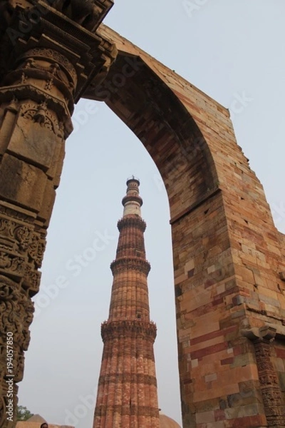 Fototapeta New Delhi, India - October 2014: Qutub minar, new delhi framed in a stone gate