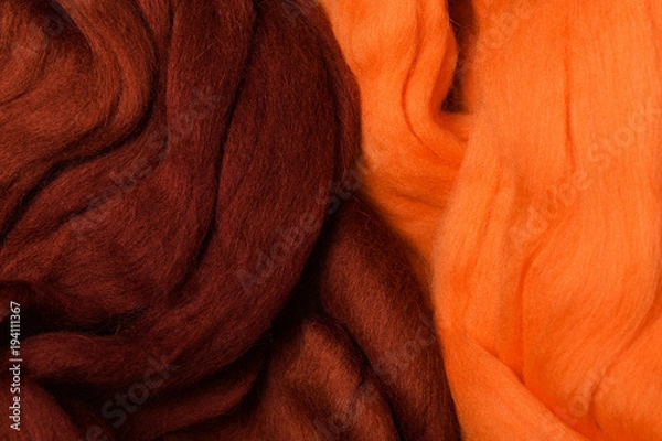 Fototapeta Bright colored merino wool for felting and needlework, hobby. The stripes of burgundy color and orange yarn folded into abstract pattern. Abstract art background