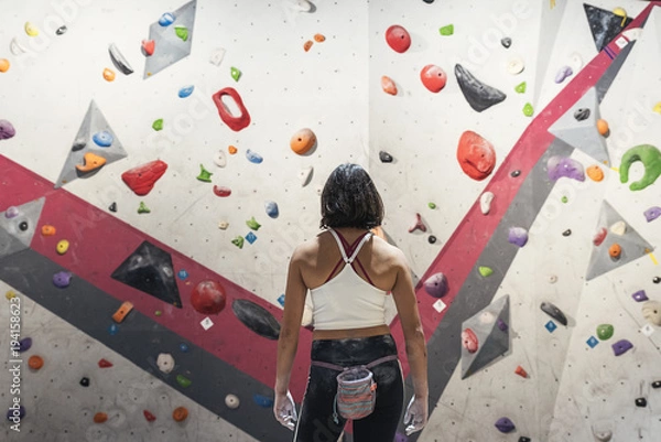 Fototapeta Unrecognizable woman ready for practice rock climbing on artificial wall indoors.