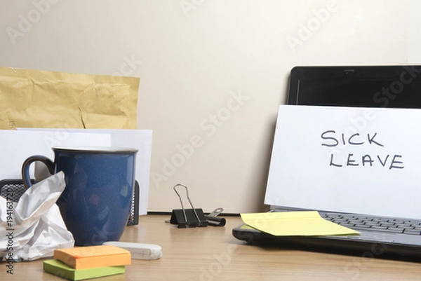 Fototapeta Sick leave message left on a messy office desk 