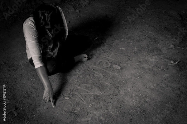 Fototapeta Give me support. Poor depressed woman folding her legs and sitting on the floor while writing help me